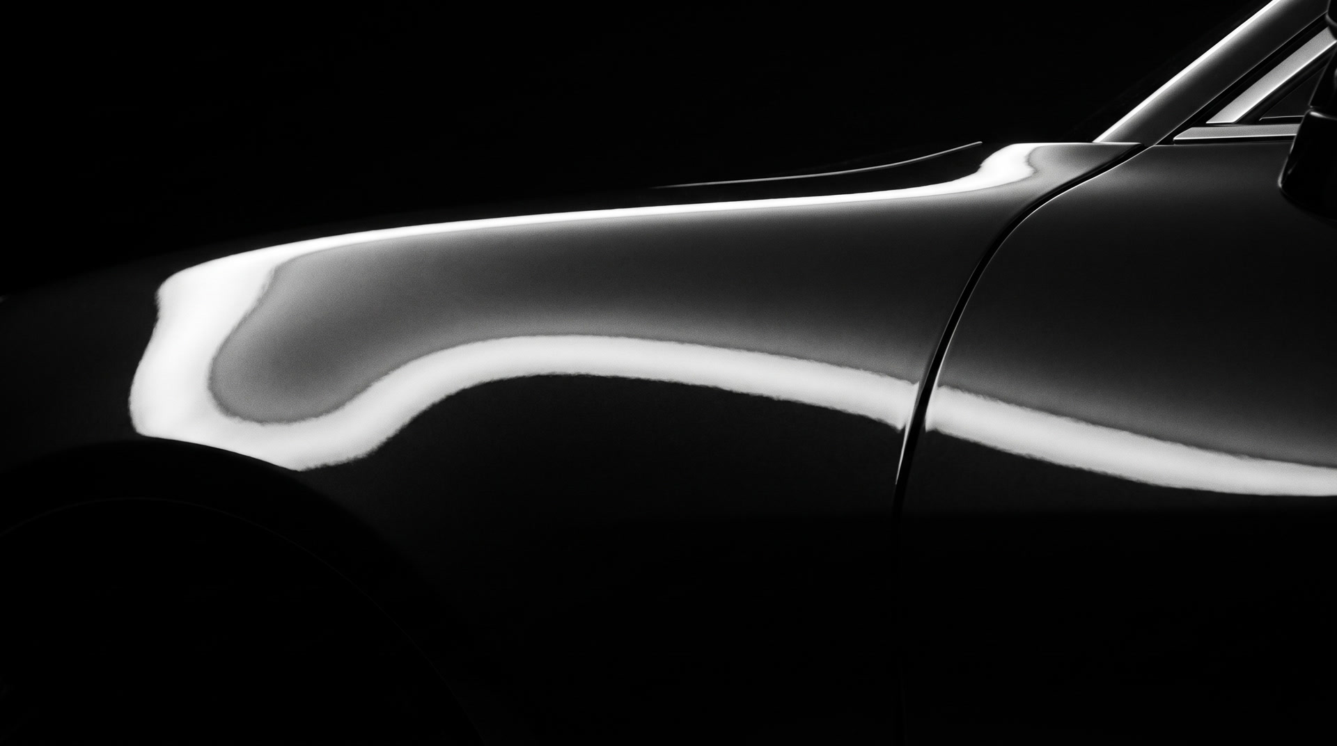 Lichtstreifen über dunklem Lack, Ausschnitt einer Fahrzeugflanke vor schwarzem Hintergrund